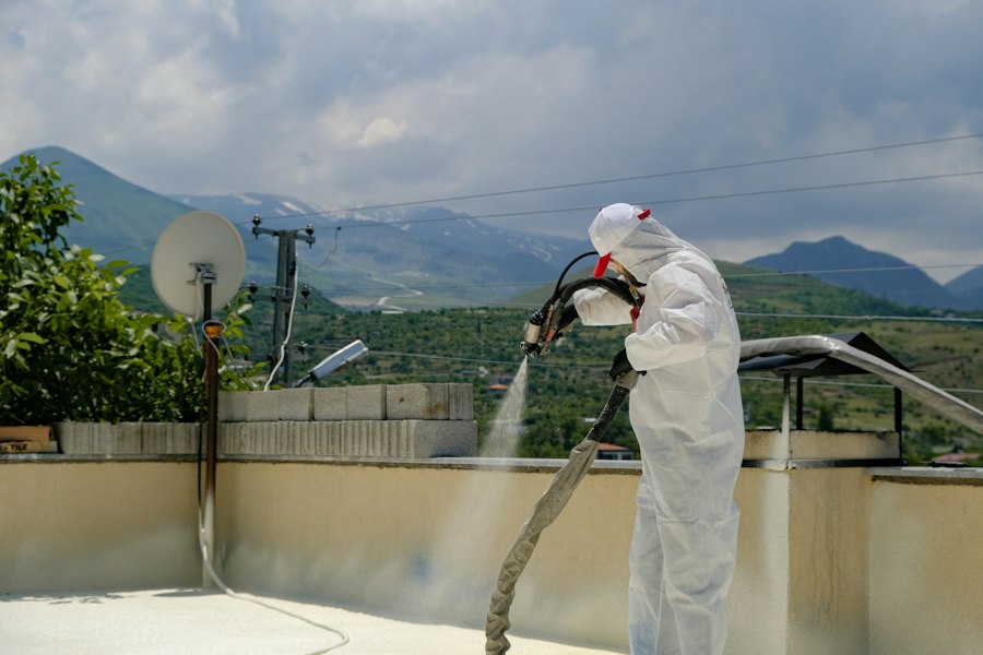 Técnico con traje de protección fumigando una terraza