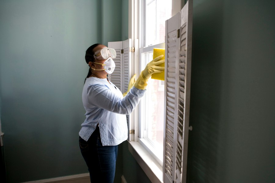 Limpieza y desinfección de ventanas con mascarilla y guantes
